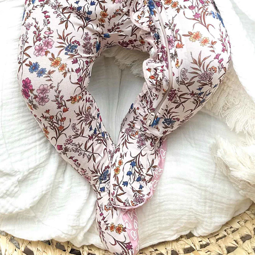 Floral-patterned onesie on a white surface with a wicker basket.