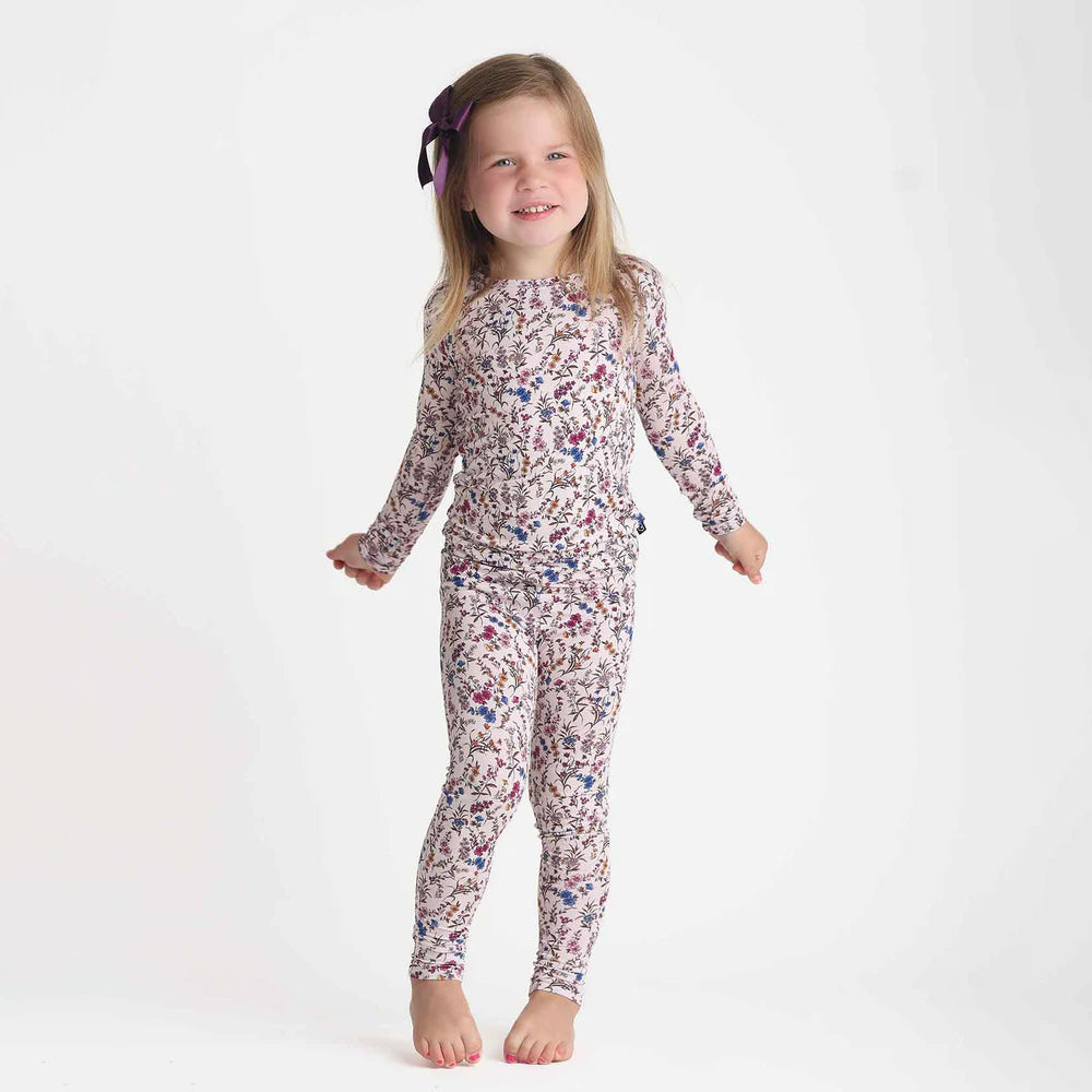 Young girl wearing a floral pajama set on a white background