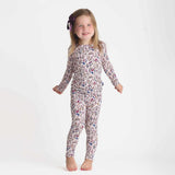 Young girl wearing a floral pajama set on a white background