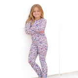 Young girl wearing a floral pajama set against a white background