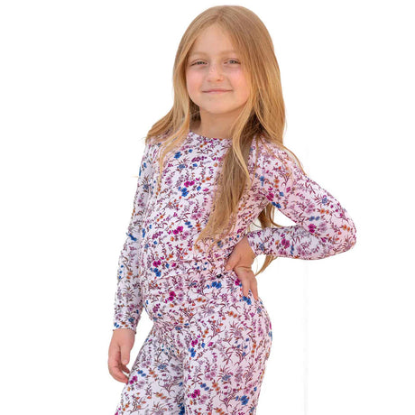 Young girl wearing a floral pajama set on a white background