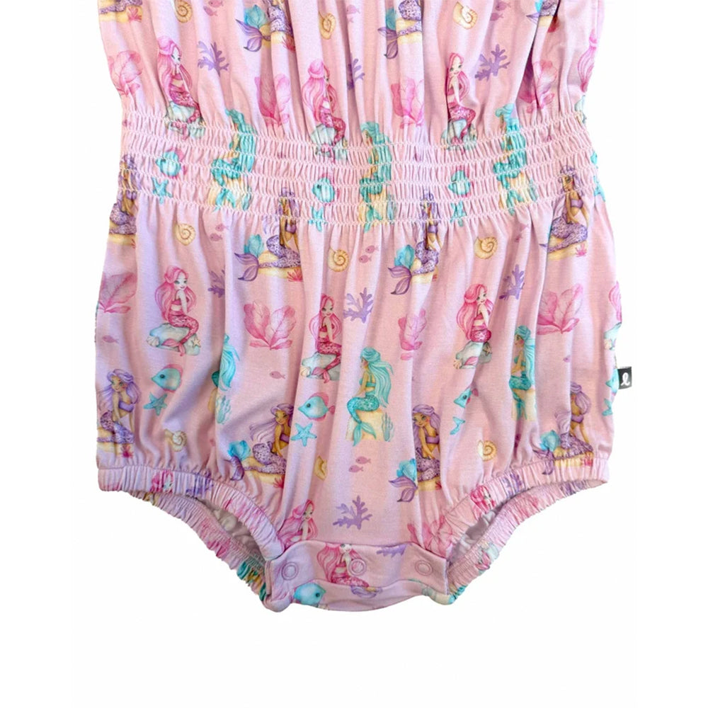 A pink baby romper with an all-over mermaid and sea life print, featuring a smocked waist and ruffled trim.