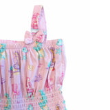 A close-up of a pink fabric garment featuring a mermaid and sea life print, with a matching pink bow detail on the shoulder strap, set against a plain white background.