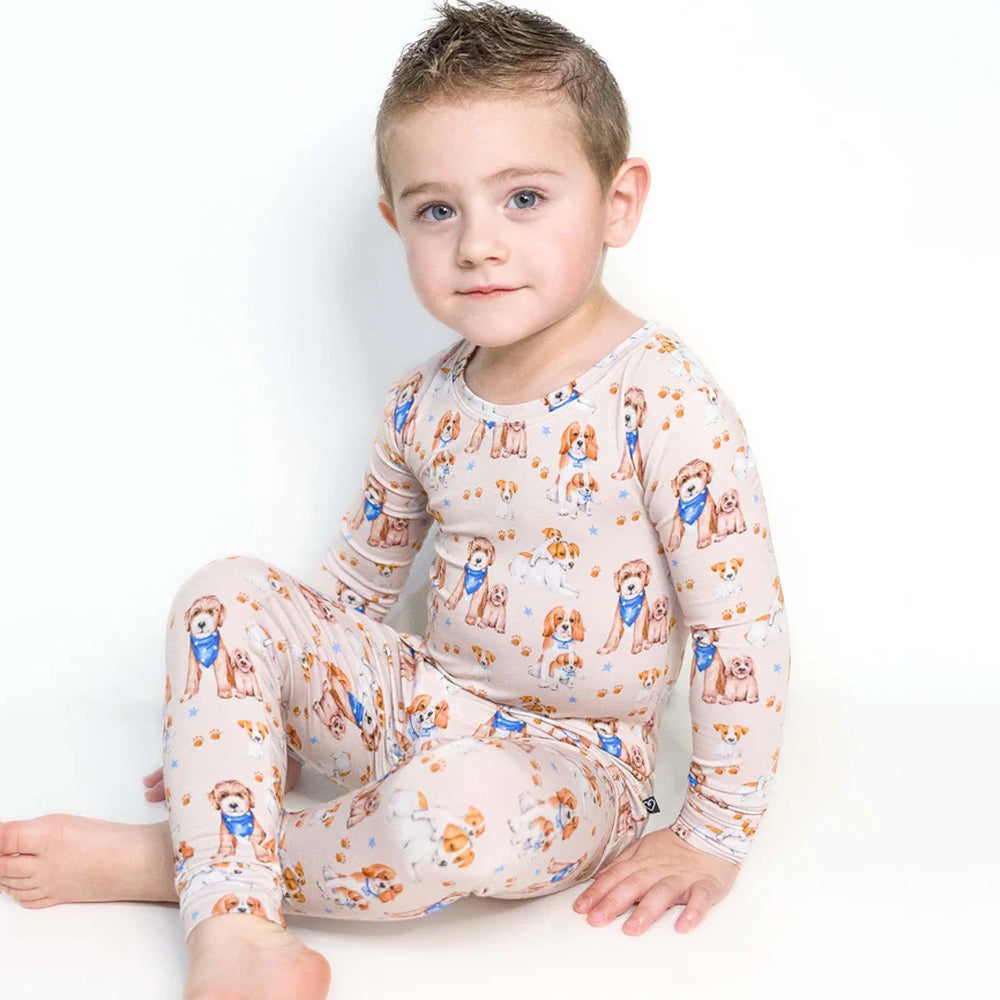 Child wearing a patterned pajamas with dogs on a white background