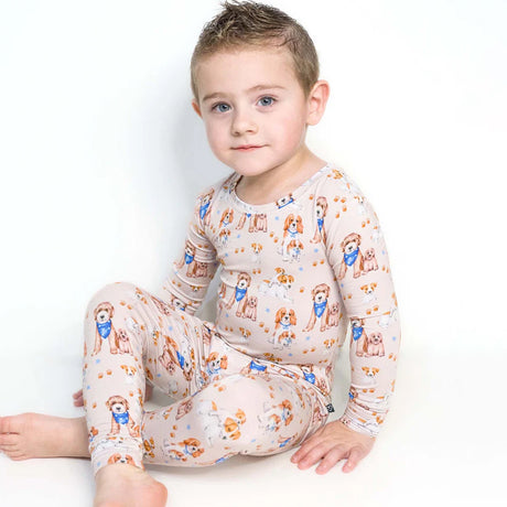 Child wearing a patterned pajamas with dogs on a white background