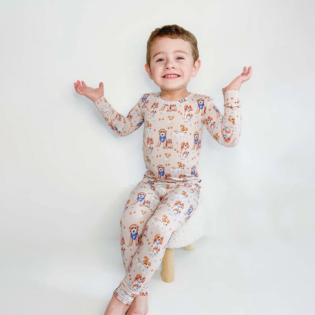 Child wearing a patterned outfit with long-sleeve top and pants on a white background