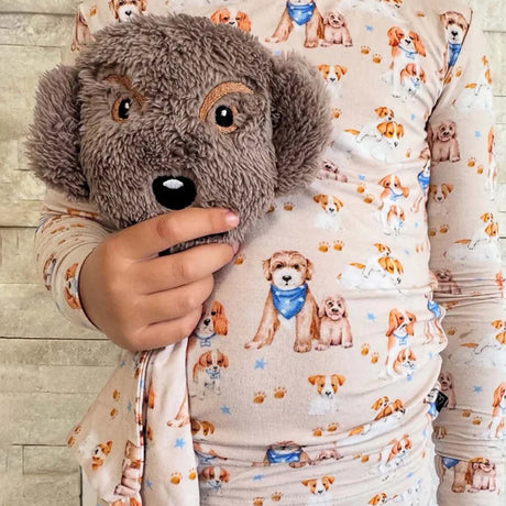 Plush dog toy with a patterned blanket featuring dog illustrations.