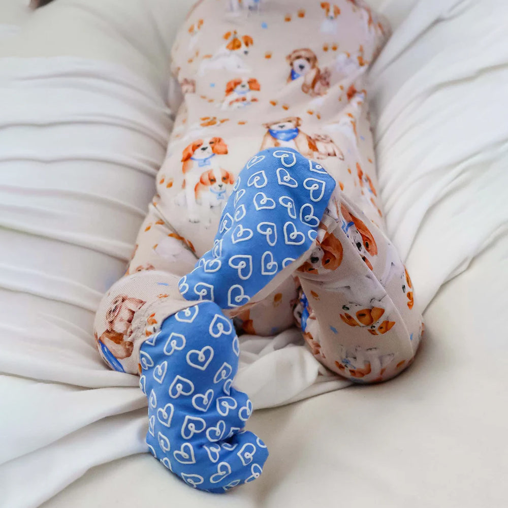 Baby wearing a onesie on a white blanket
