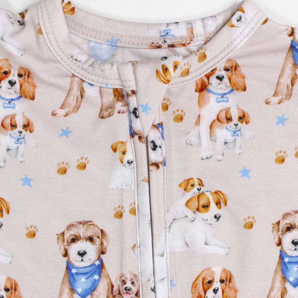 Baby onesie with dog pattern on a beige background