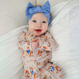 Baby wearing a blue headband on a white blanket