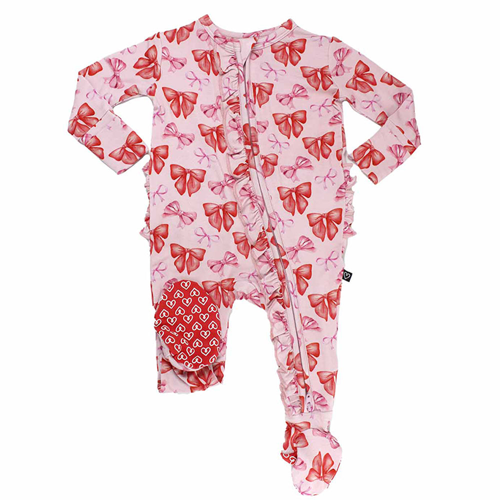 Pink baby onesie with red bow pattern on a white background
