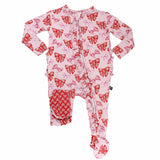 Pink baby onesie with red bow pattern on a white background