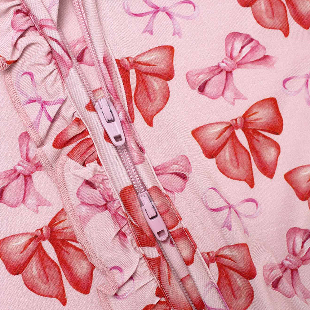 Pink zipper on a pink fabric background with red and pink bows