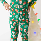 Child wearing festive pajama pants with Christmas-themed pattern in front of a decorated tree.
