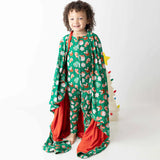 Child wearing a green patterned outfit with red accents on a white background