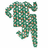 Children's Christmas-themed pajama set with Santa Claus, reindeer, and candy cane pattern on a green background.