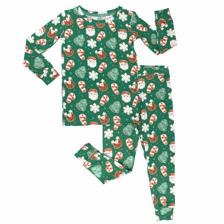 Children's Christmas-themed pajama set with Santa Claus, reindeer, and candy cane pattern on a green background.