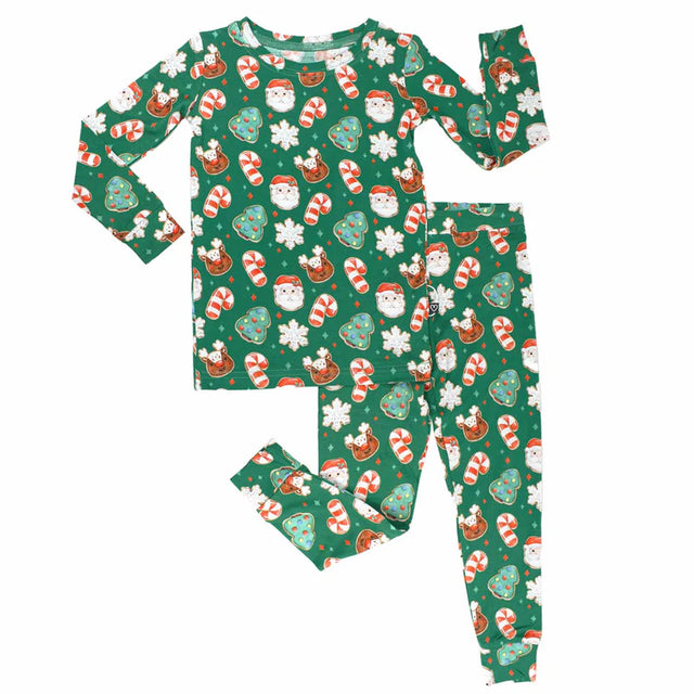 Children's Christmas-themed pajama set with Santa Claus, reindeer, and candy cane pattern on a green background.
