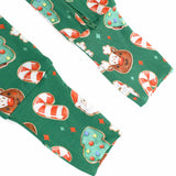 Green fabric with Christmas-themed pattern including cookies, candy canes, and trees on a white background.