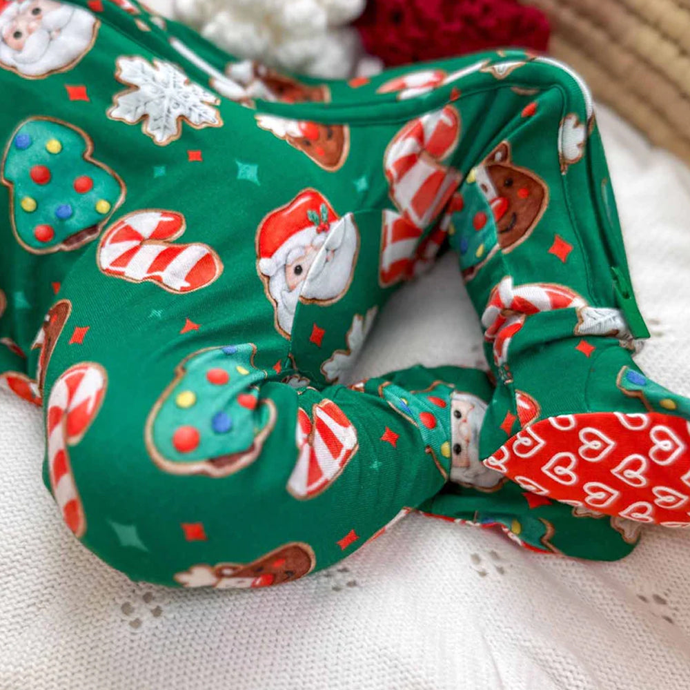 Christmas-themed fabric with Santa Claus, candy canes, and cookies on a green background.
