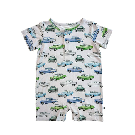 A close-up of a short-sleeve baby romper or bodysuit with an all-over vintage car print on a light cream background. The print features retro cars in light blue, medium blue, green, and white, with a buttoned chest pocket.
