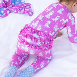 Child wearing pink pajama pants with white dog pattern on a white background