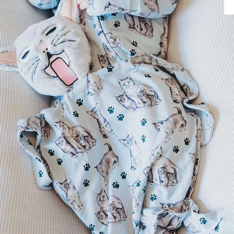 Baby blanket with cat pattern and plush toy on beige surface