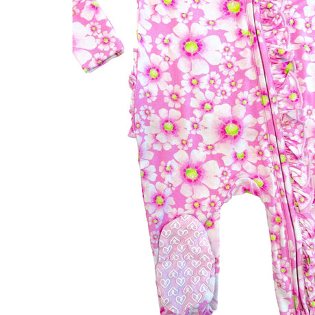 Pink baby footed sleeper with a white and pink cherry blossom floral print, featuring ruffle trim down the side and a heart-patterned cuffed ankle.