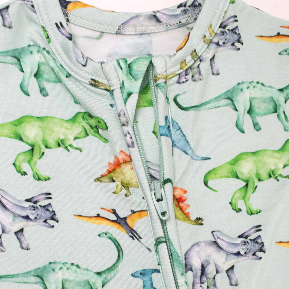 Children's onesie with dinosaur pattern on a light blue background