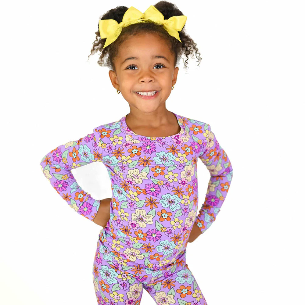 Child wearing a colorful floral outfit on a white background