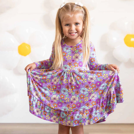 Young girl wearing a floral dress with a plain background