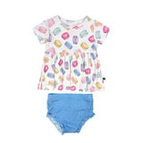 Children's outfit with colorful macaron pattern top and blue bloomers on a white background