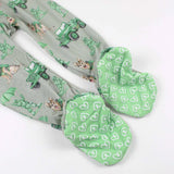 Green patterned fabric with white hearts and a white object on a light gray background