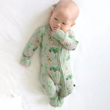 Baby wearing a green and gray patterned onesie on a white background