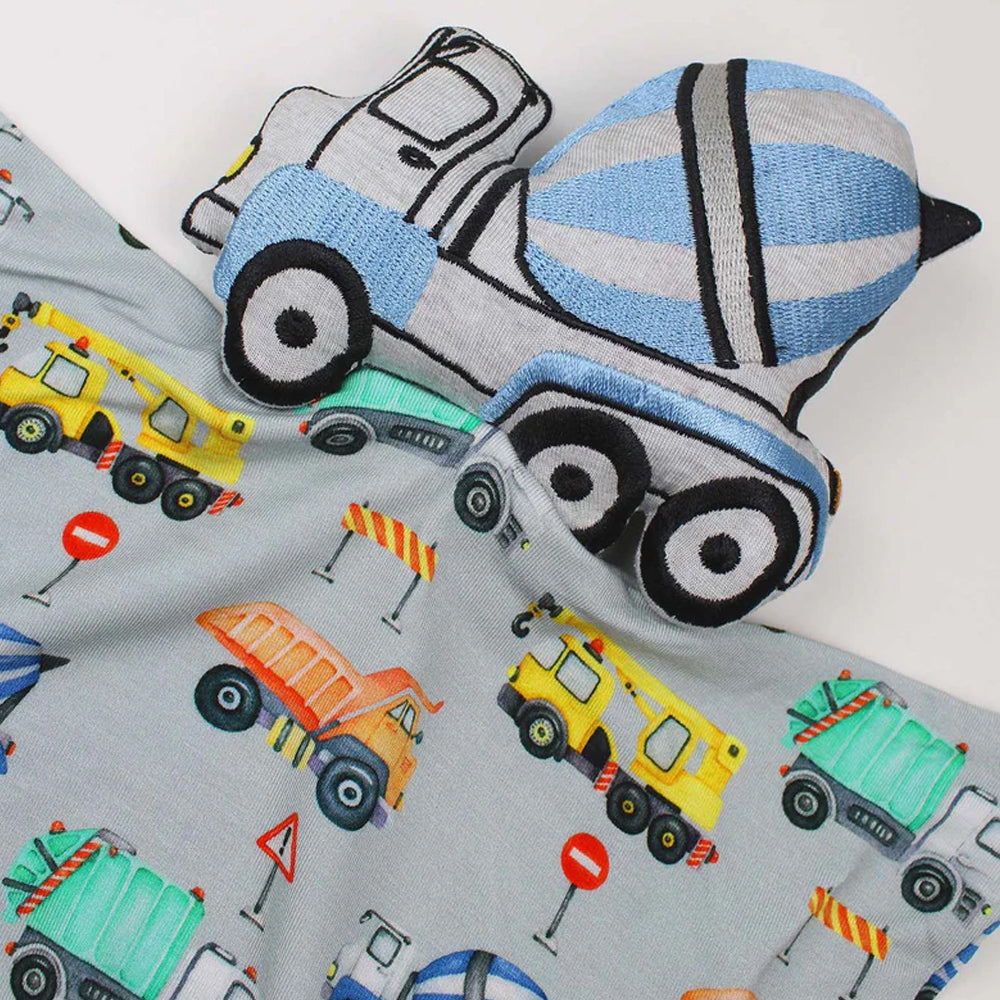 Knitted toy cement mixer on a fabric background with construction vehicle pattern blanket