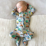Baby wearing a onesie with vehicle pattern on a textured surface