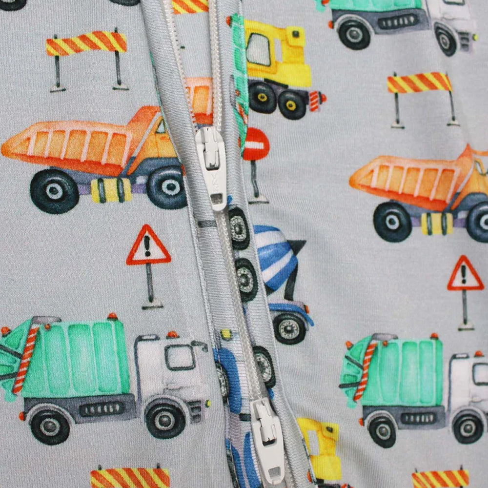 Fabric with construction vehicle pattern and zipper on a gray background
