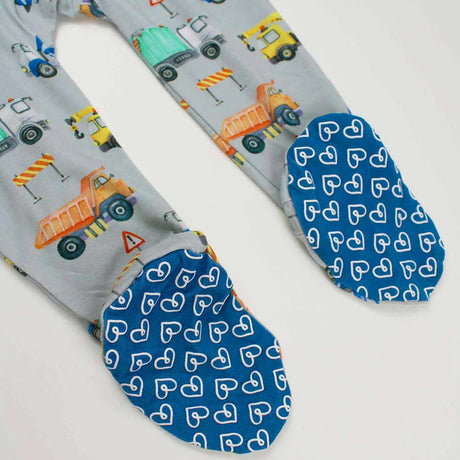 Footie with construction vehicle pattern and blue feet with heart pattern on a white background
