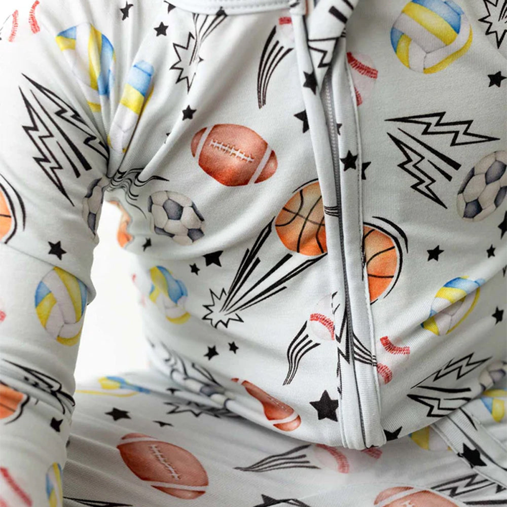 Folded fabric with sports-themed pattern including balls and stars on a white background