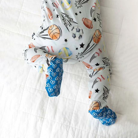 Baby onesie with sports-themed print on a white background
