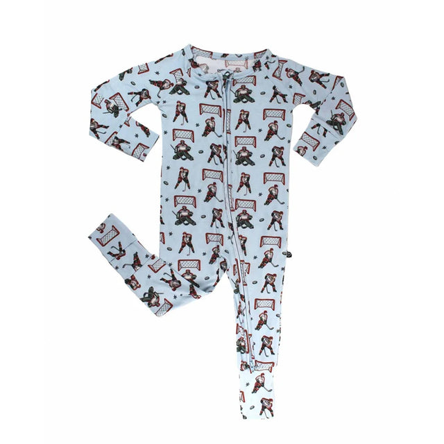 A baby long-sleeve footed one-piece pajama with a light blue background and an all-over hockey print featuring players, skates, and goals.
