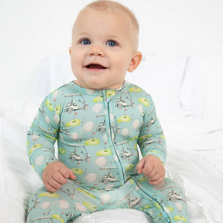 Baby wearing a light blue pajama with animal prints on a white background