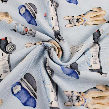 Fabric with cartoon police cars and dogs pattern on a light blue background