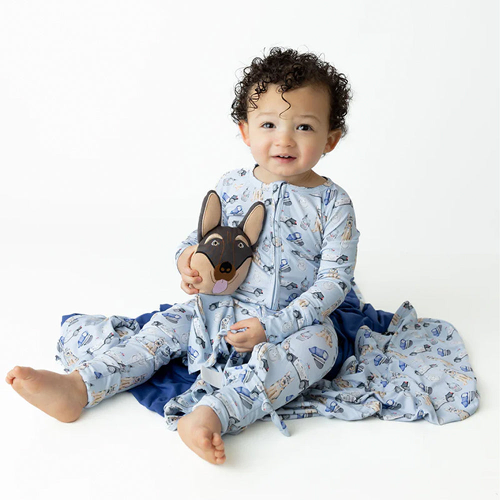 Baby wearing a blue animal-themed onesie sitting on a white background