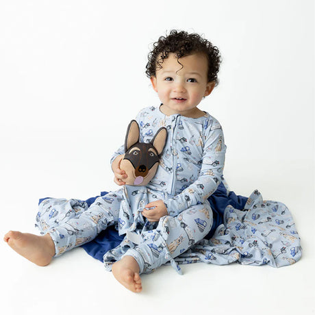 Baby wearing a blue animal-themed onesie sitting on a white background