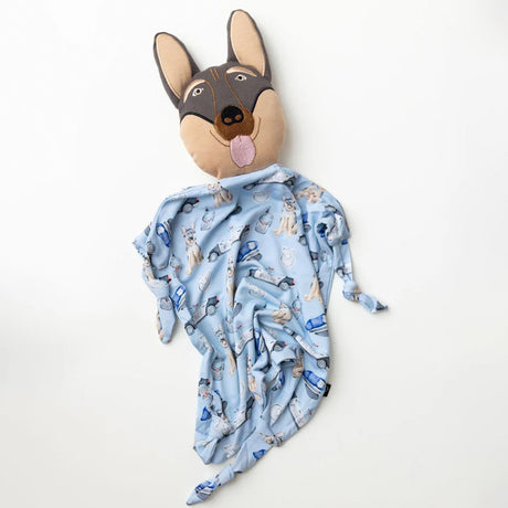 Dog-shaped plush toy with a blue patterned blanket draped over it on a white background