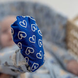 Blue footie with white heart patterns on a blurred background