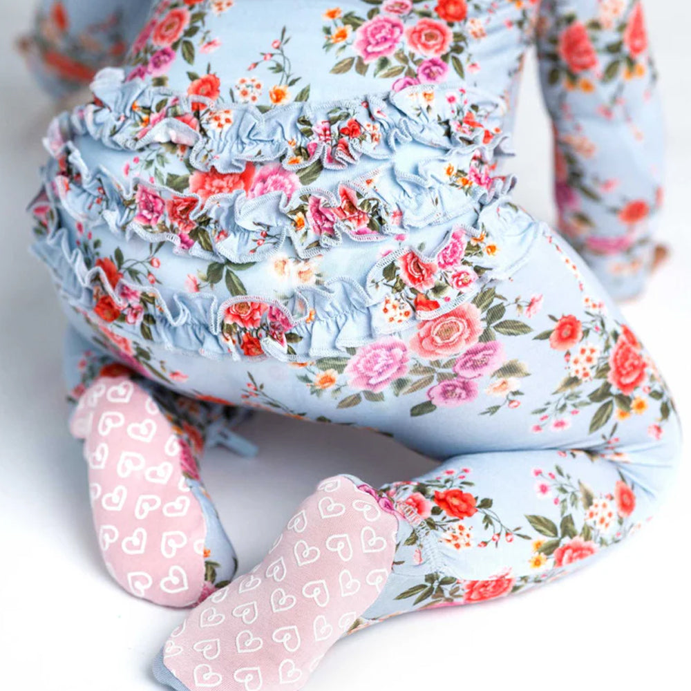 Floral-patterned onesie with ruffles around the back on a white background