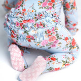 Floral-patterned onesie with ruffles around the back on a white background