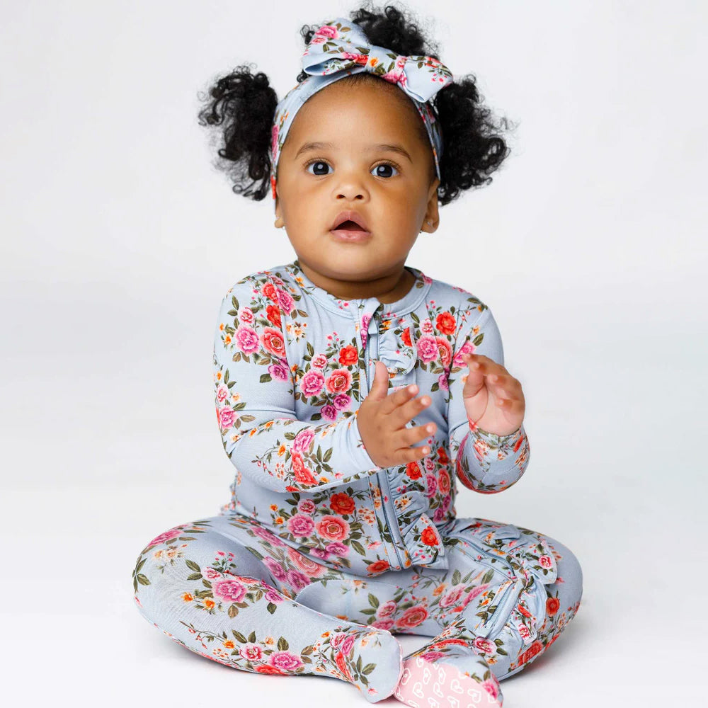 Baby wearing a floral outfit with a white background